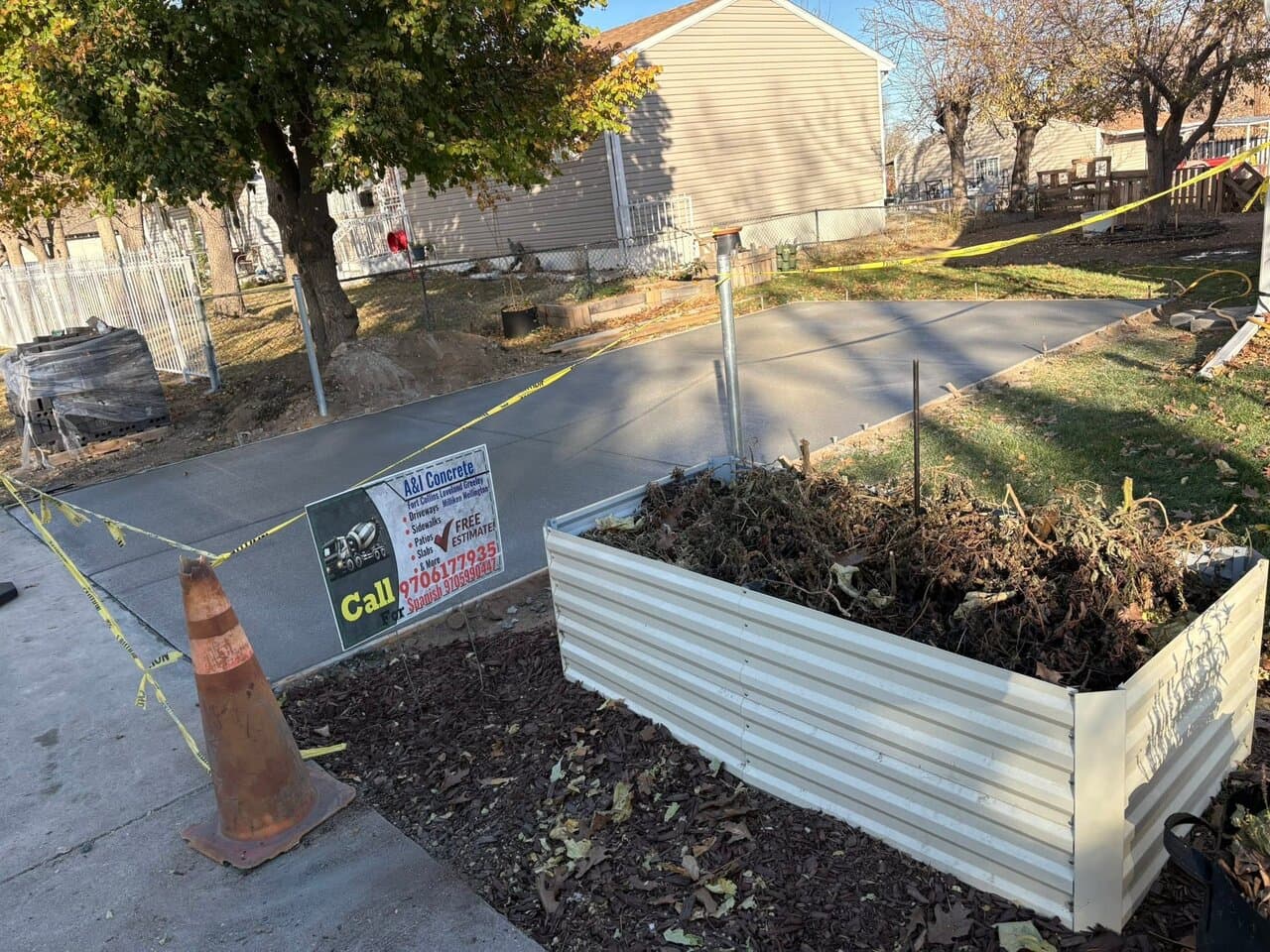 Residential landscape project with concrete driveway and metal planter