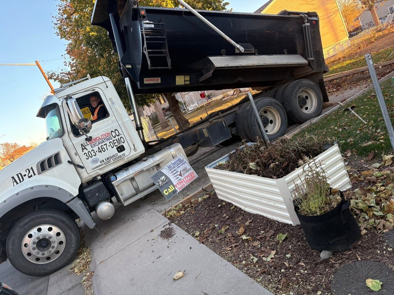 Dump truck unloading materials during a landscaping job