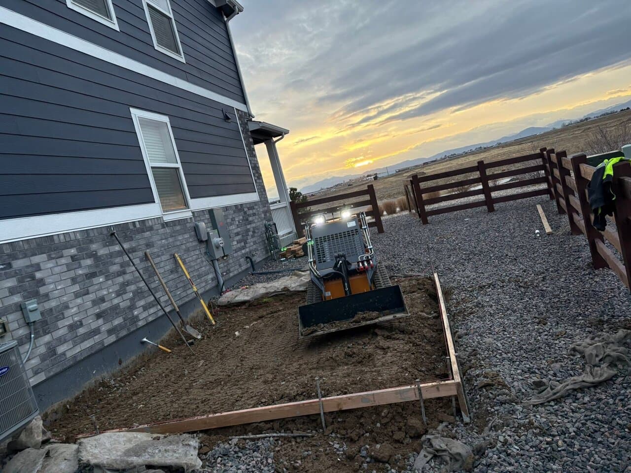 Concrete foundation work in progress with excavator and gravel base