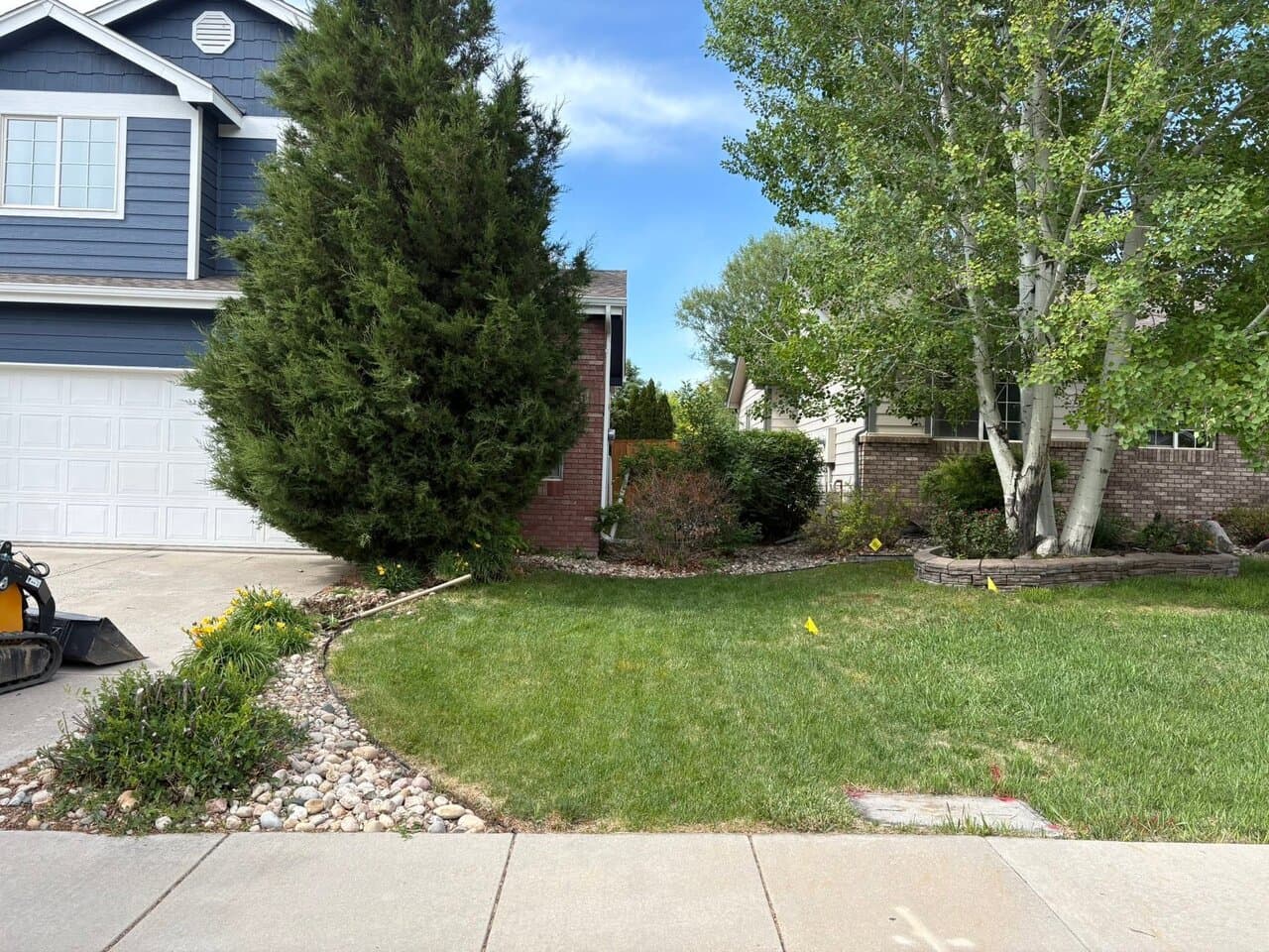 Finished residential landscaping with manicured lawn and decorative rock borders