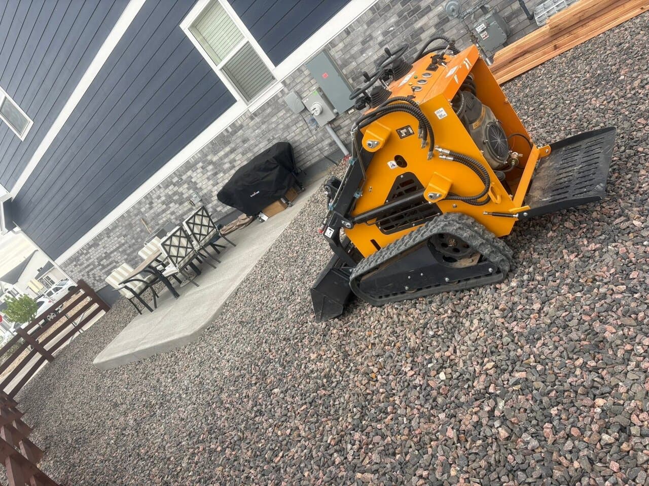 Yellow skid-steer loader with attachment viewed from above