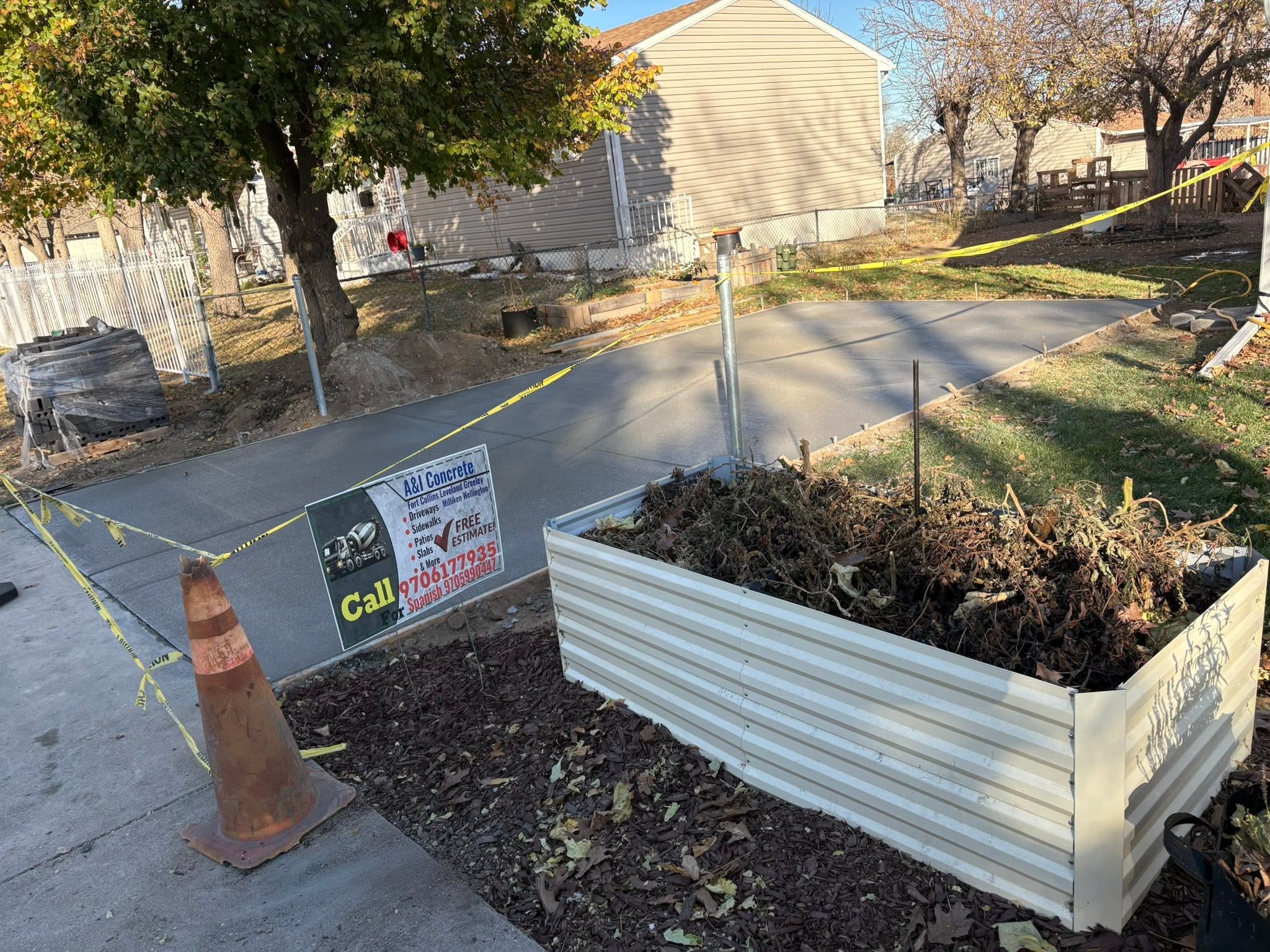 Residential landscape project with concrete driveway and metal planter