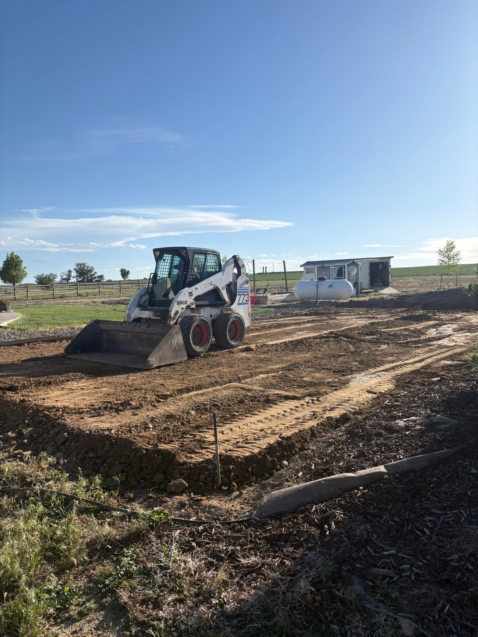 Skid-steer loader grading dirt at construction site